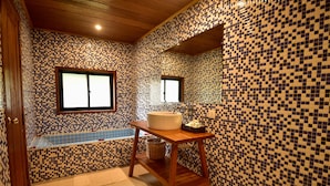 A bathroom with mosaic tile walls, a wooden vanity, a sink, and a bathtub. - Angkor Heart Bungalow- Private Pool (Siem Reap)