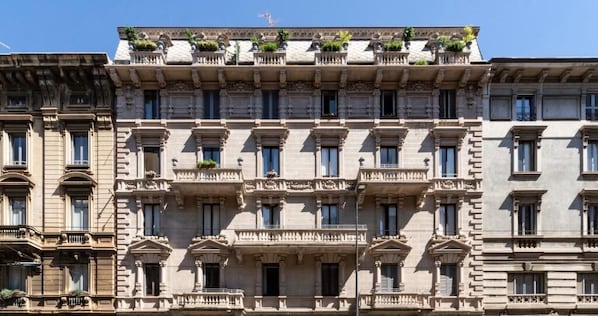 A multi-story building with a classical architectural style, featuring symmetrical balconies and large windows.