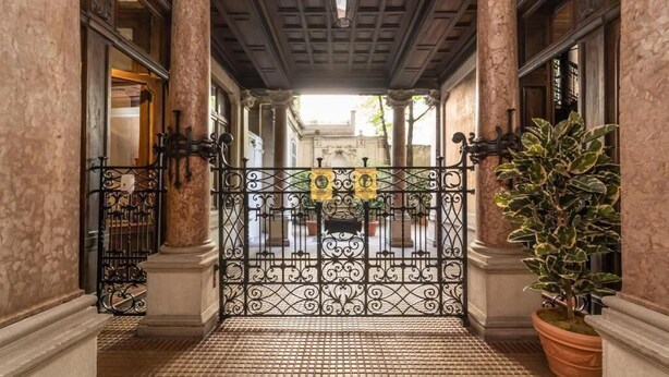 A corridor with ornate iron gates, columns, and a tiled floor. - Le Dimore Suites Milano (Milan)