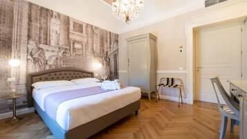 A neatly arranged bedroom with a large bed, a chandelier, a wardrobe, and a mirror.