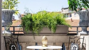 A small outdoor seating area with a round table and two chairs, surrounded by patterned floor tiles and decorative metal elements. - Le Dimore Suites Milano (Milan)