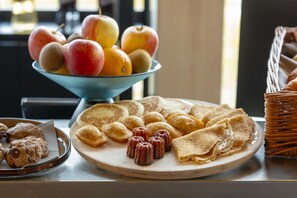 A breakfast buffet with a variety of pastries, cookies, and a bowl of fruit. - Quai Central (Tourcoing)