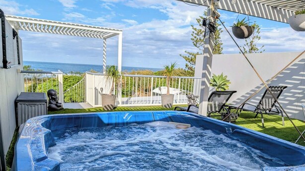 A hot tub with a view of the ocean, surrounded by a white pergola and outdoor furniture. - Beachfront, ocean views, private rooftop terrace with spa, pool, walk to beach (Marcoola)