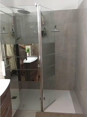 Chuveiro, secador de cabelo, toalhas de banho, papel higiênico
