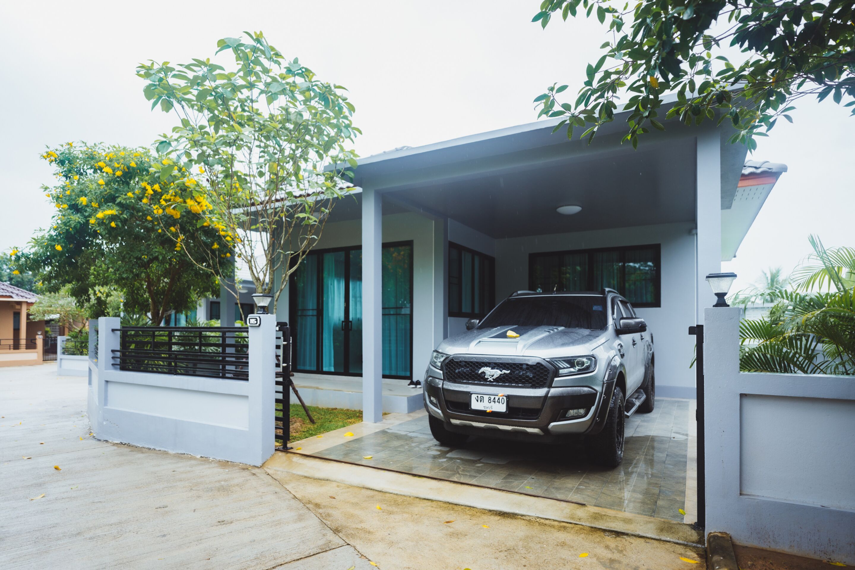 Una casa moderna con entrada para coches y un vehículo estacionado.
