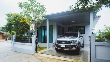 Una casa moderna con entrada para coches y un vehículo estacionado.