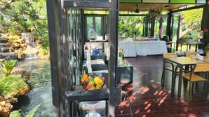 Een restaurant met een waterval, terras en een buffet.