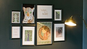 Een moderne woonkamer met leren banken, een glazen salontafel en kunstwerken in lijsten aan de muur.