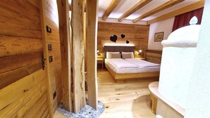 A wooden cabin interior with a bed, a small table, and a bench. - Park Hotel Sport (Andalo)