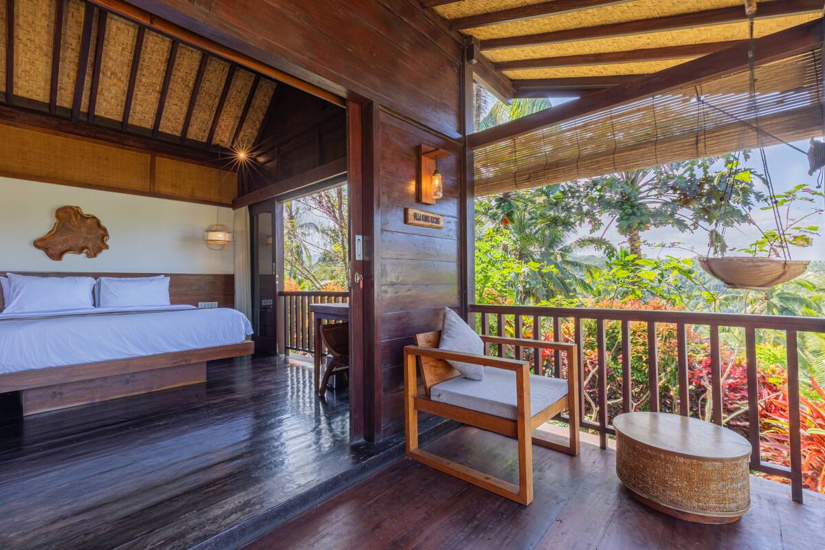 A wooden room with a bed, a chair, and a hanging basket.