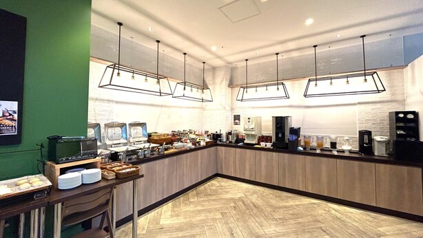 Een modern café met een lange toonbank, koffieapparatuur en een visgraat houten vloer.