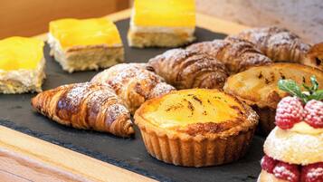 A variety of pastries and desserts on a slate serving board.