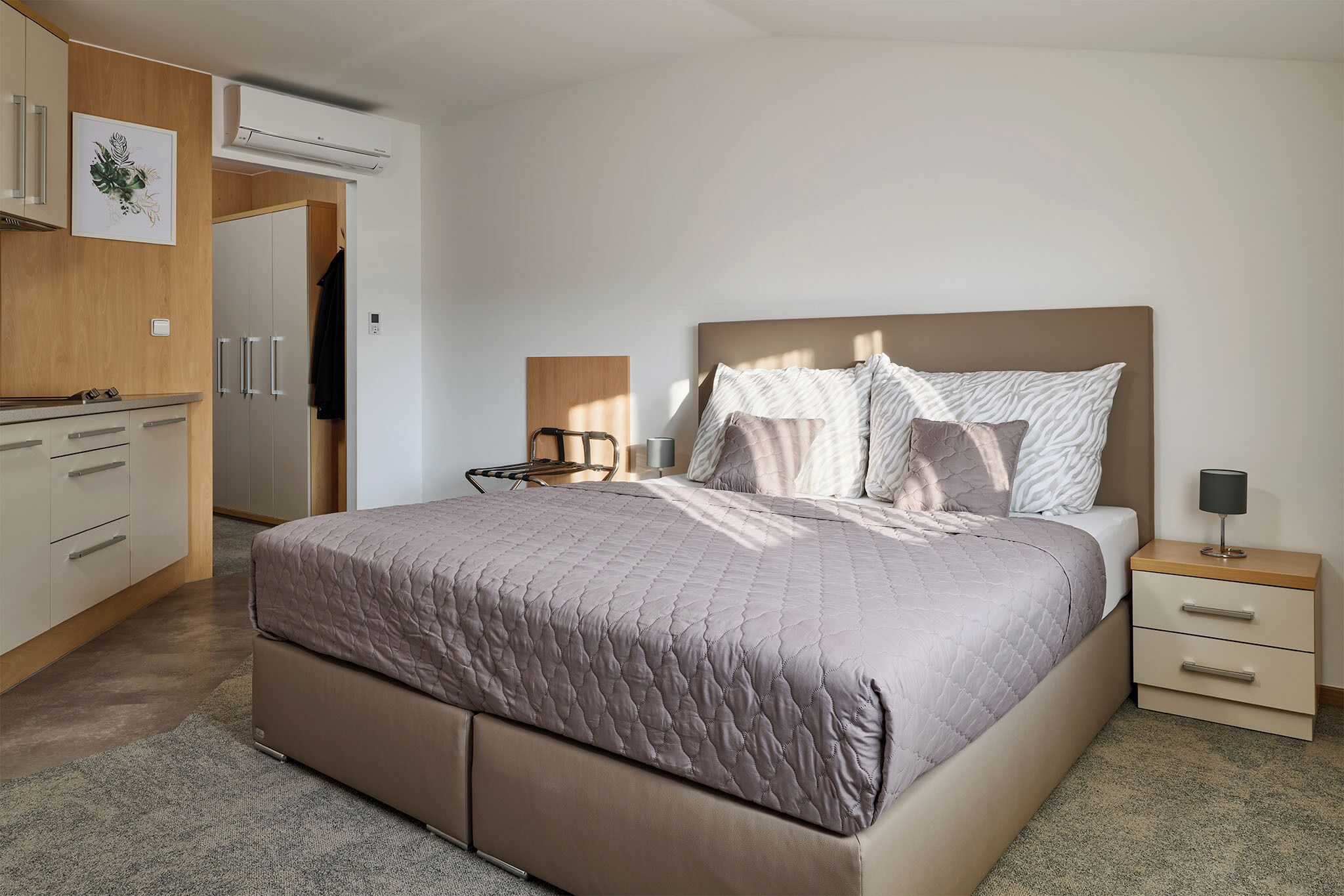 Ein Schlafzimmer mit Bett, Nachttisch und Kleiderschrank.