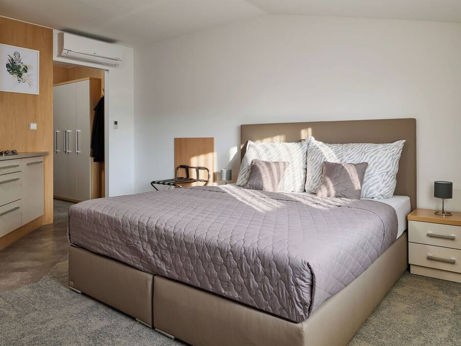 A bedroom with a bed, bedside table, and a wardrobe.