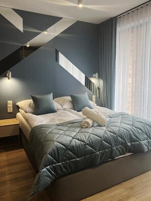Un dormitorio moderno con una cama, mesitas de noche y una escalera.