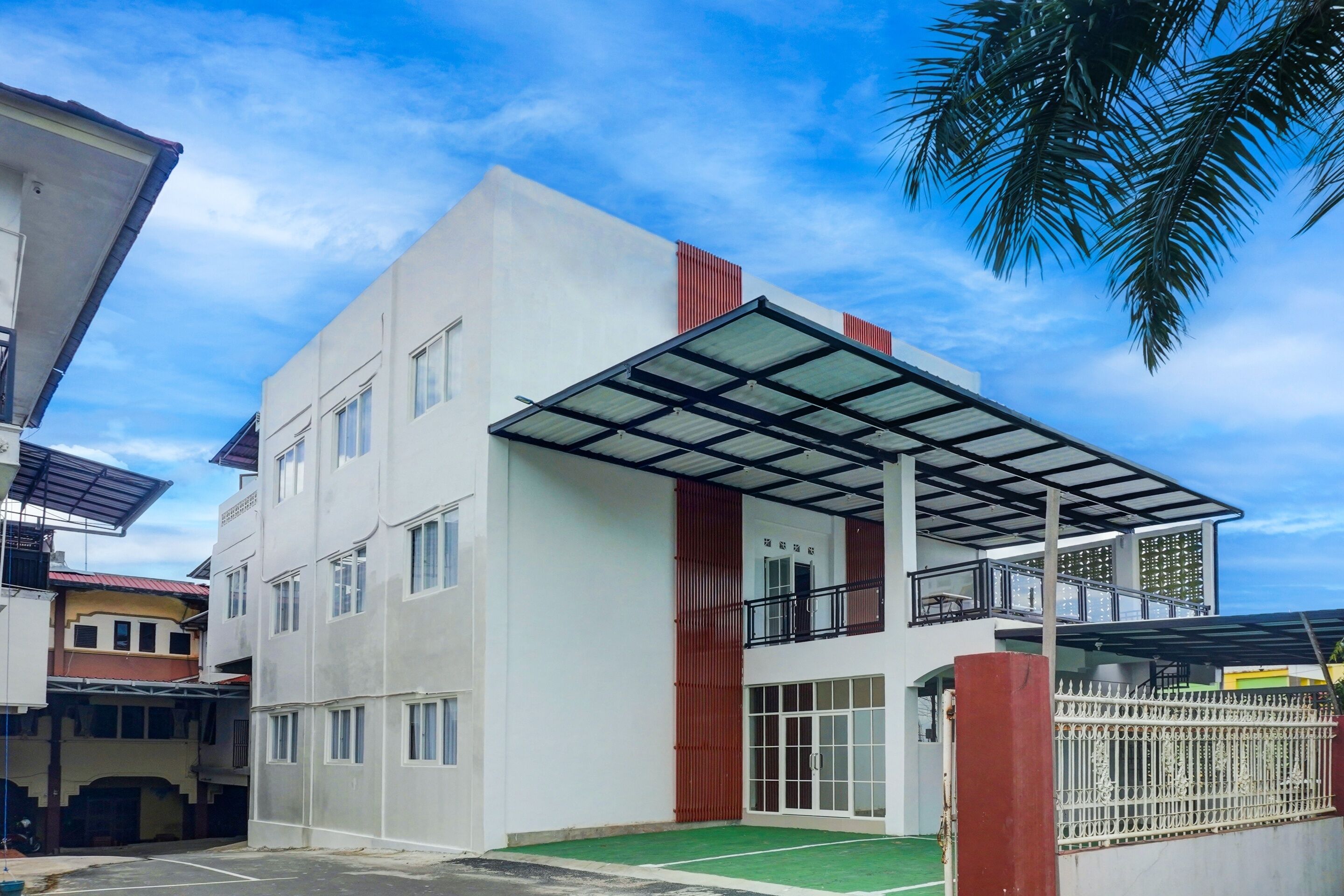 A modern building with a flat roof, large windows, and a covered entrance.