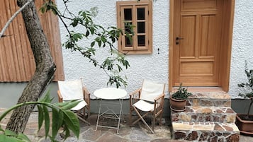 Relax in a serene outdoor space with a stone-paved patio and comfortable seating for two.