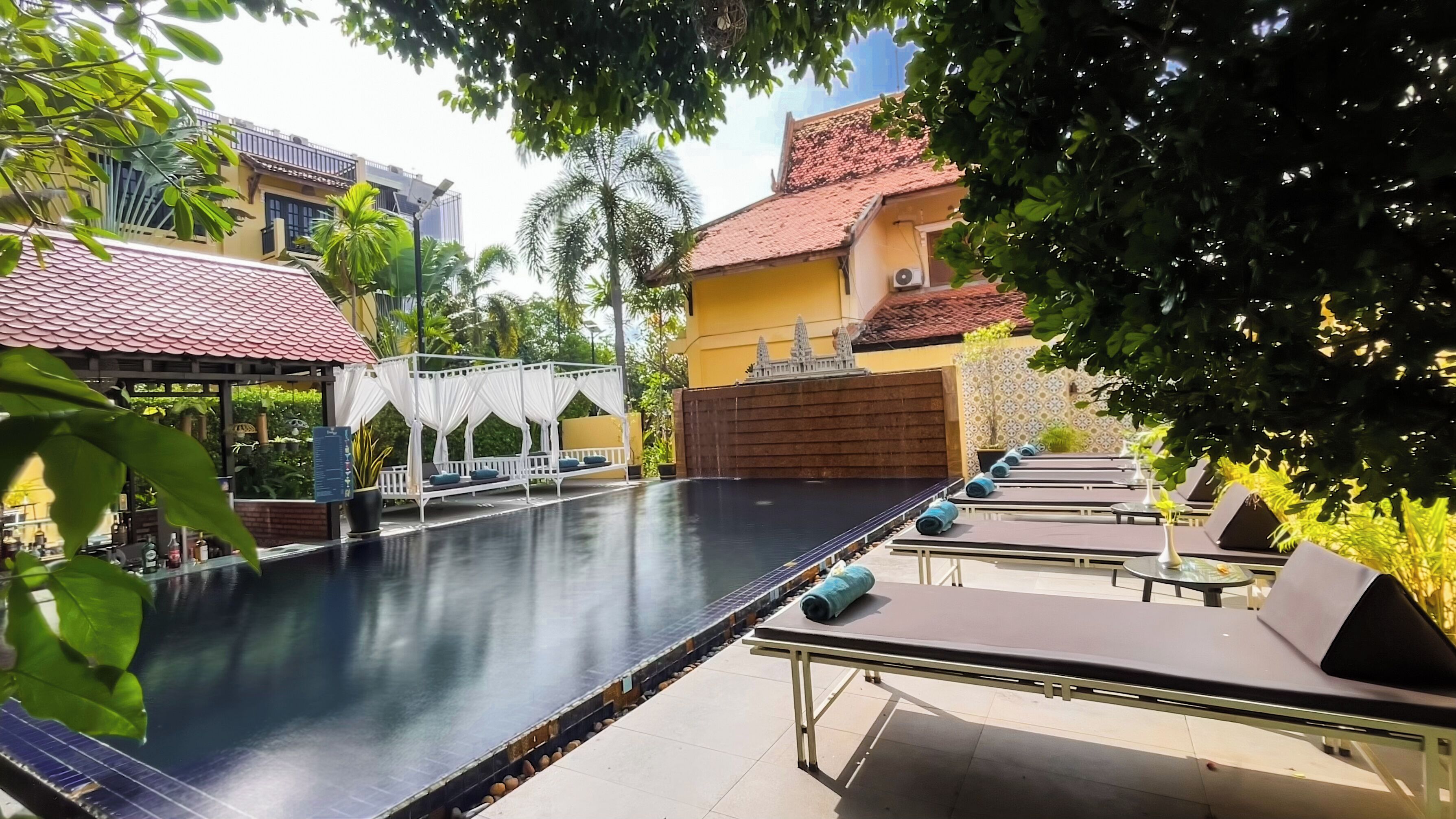 A swimming pool with lounge chairs and a gazebo.