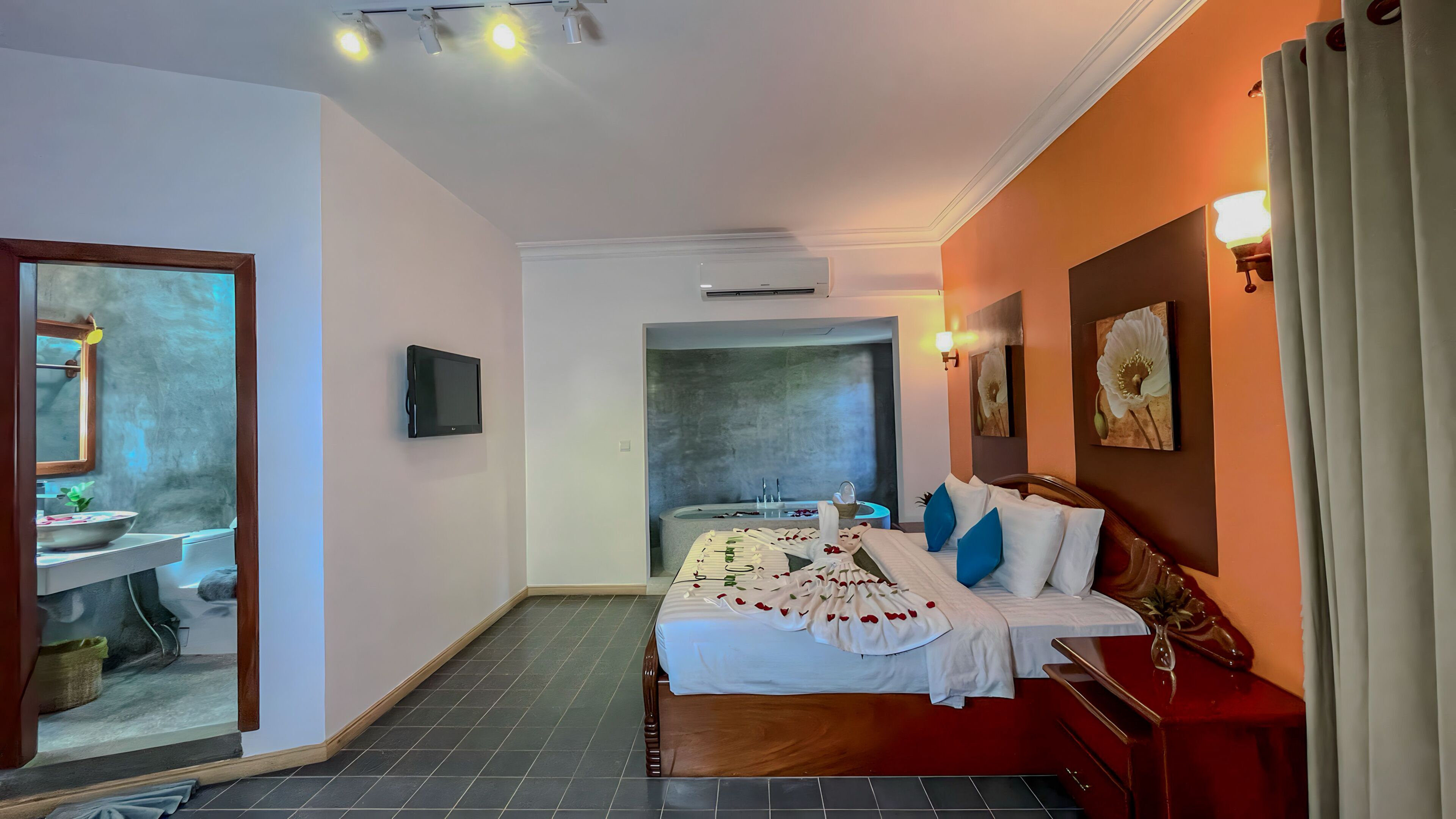 A hotel room with a bed, a bathroom, and a TV.