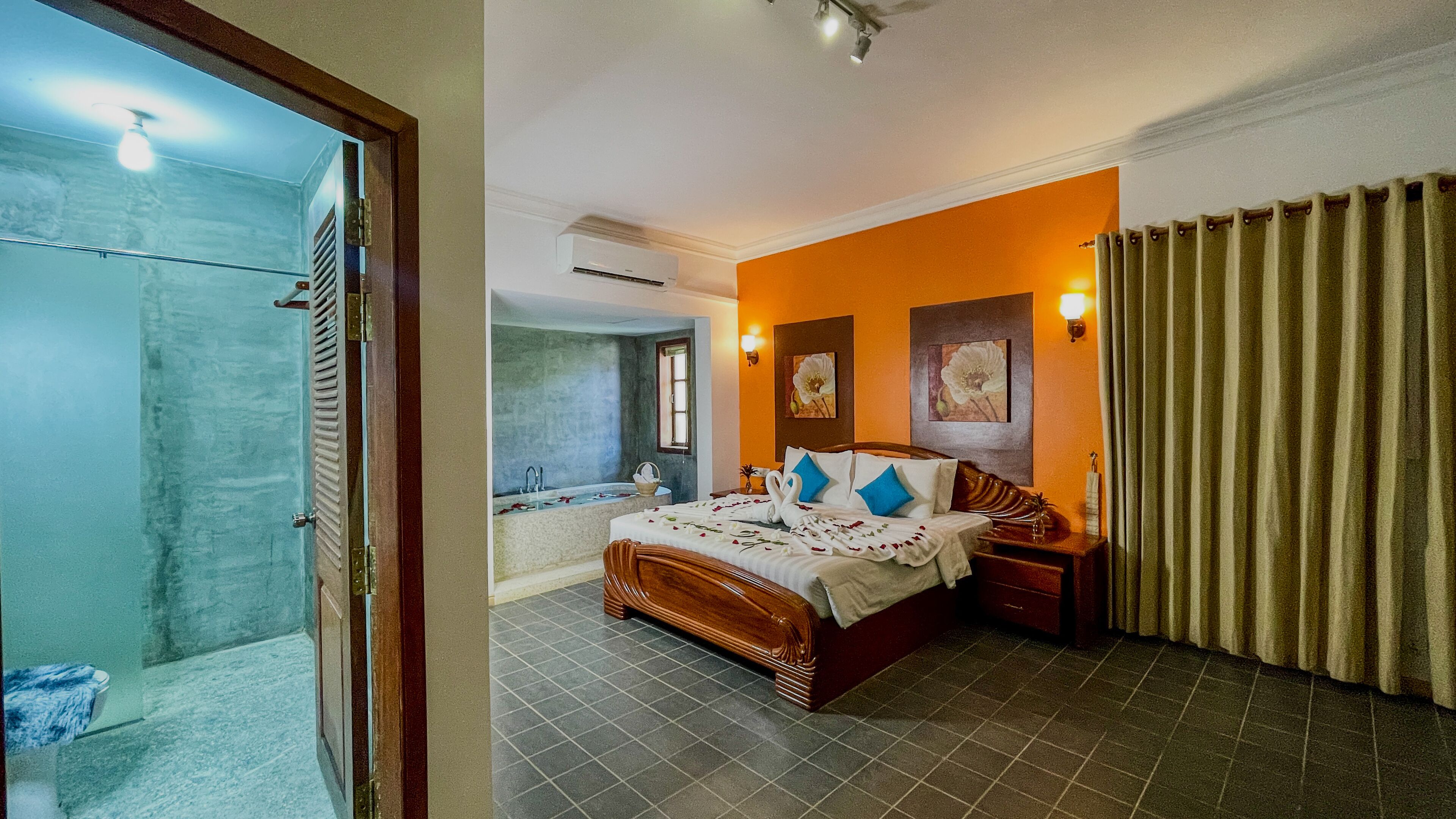 A hotel room with a bed, a bathroom, and a shower area.