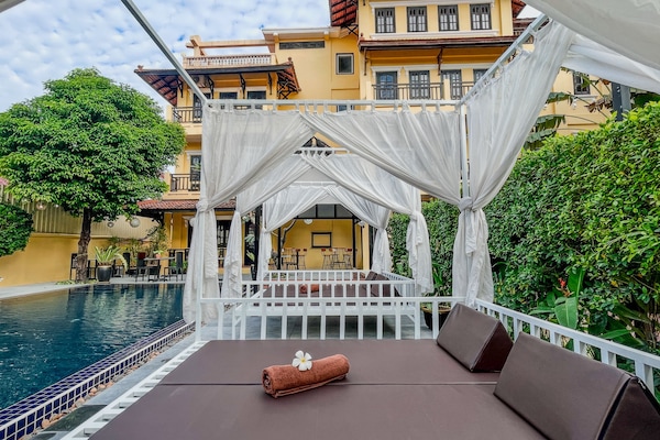 Una piscina al aire libre, camas de piscina gratis, sombrillas