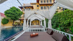 A poolside lounge with a canopy, seating, and a view of the pool. - Villa Indochine d'Angkor (Siem Reap)