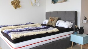 A bedroom with a bed, a nightstand, and decorative wall art. - Apartment Tälerblick Maxi - with large balcony and great view (Böbrach)