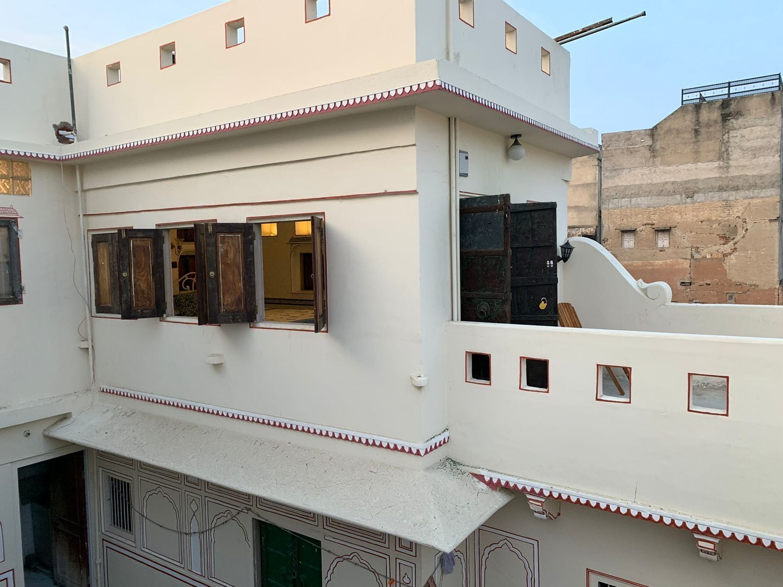 A multi-story building with a flat roof, multiple windows, and decorative trim.