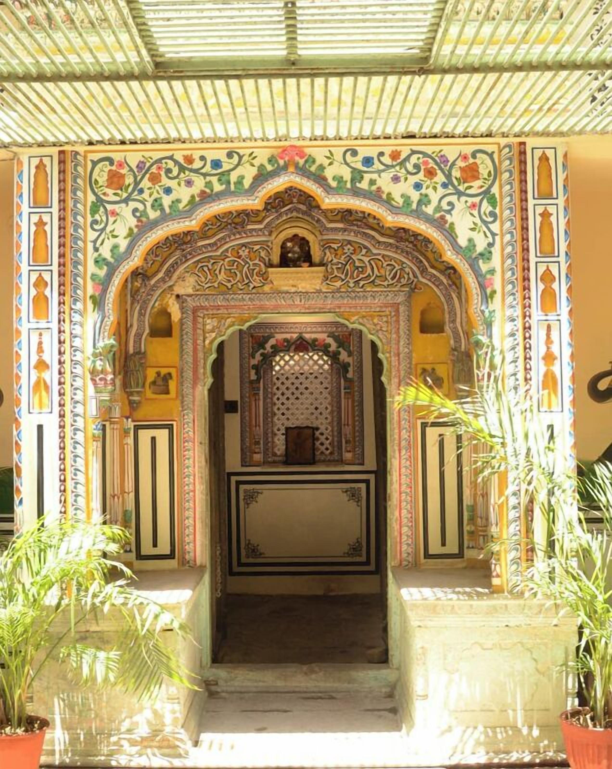 An ornate entrance with intricate floral and geometric patterns, a central archway, and a small shrine.
