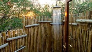 Une clôture en bois sur laquelle est fixée une pomme de douche.
