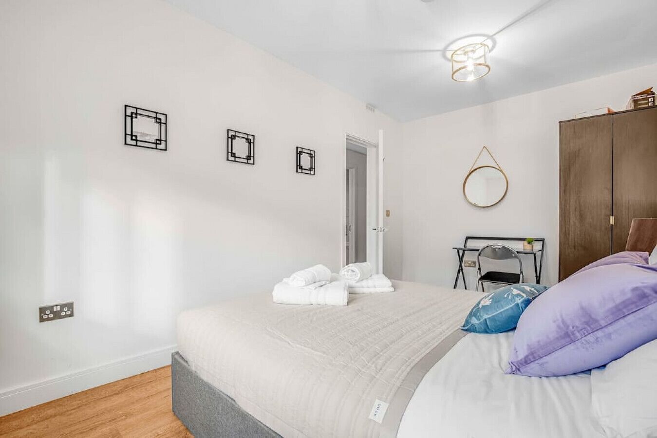 Une chambre à coucher avec un lit, un bureau, une chaise et une armoire.