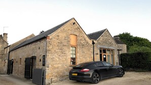 A stone building with a black car parked in front.
