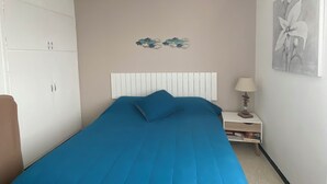 Una camera da letto con un letto grande, un armadio, un comodino con lampada e un quadro appeso al muro.