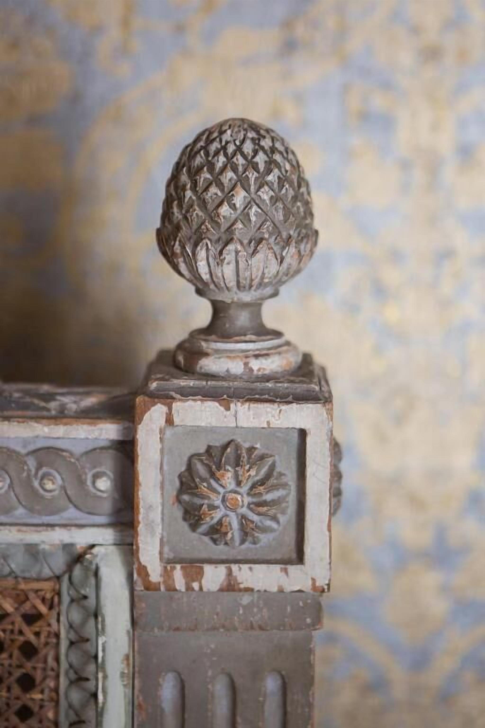 A decorative metal piece with a spherical top and a floral design on a wall.