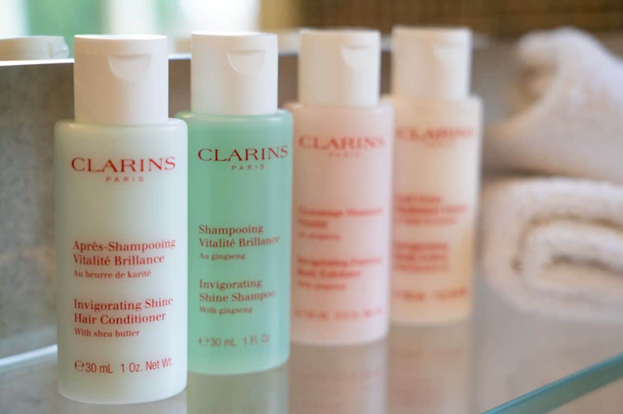 A row of Clarins Paris hair care products on a shelf.