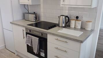 Apartamento | Cocina privada | Frigorífico, microondas, horno y placa de cocina