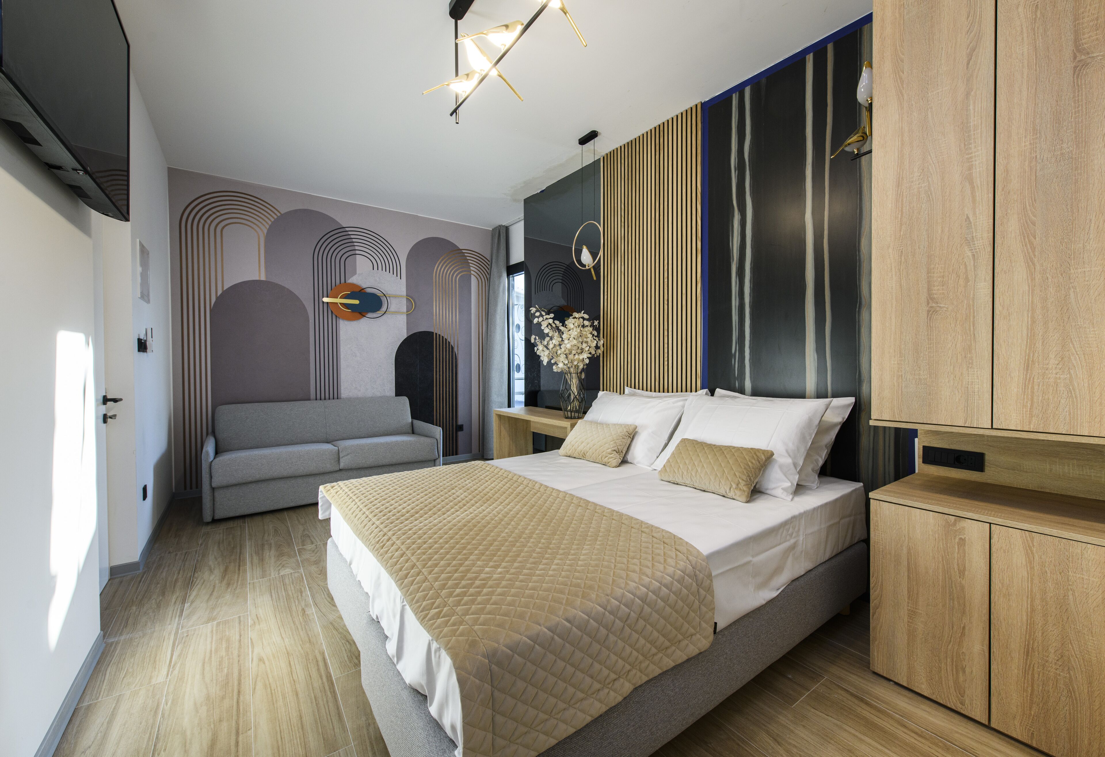 A modern bedroom with a bed, a sofa, and a nightstand.