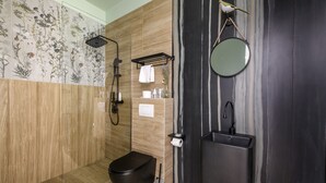 A modern bathroom with a shower, toilet, and sink.