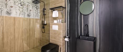 A modern bathroom with a shower, toilet, and sink.