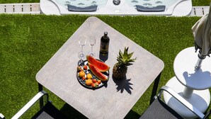 A hot tub with a table and chairs in a grassy area.