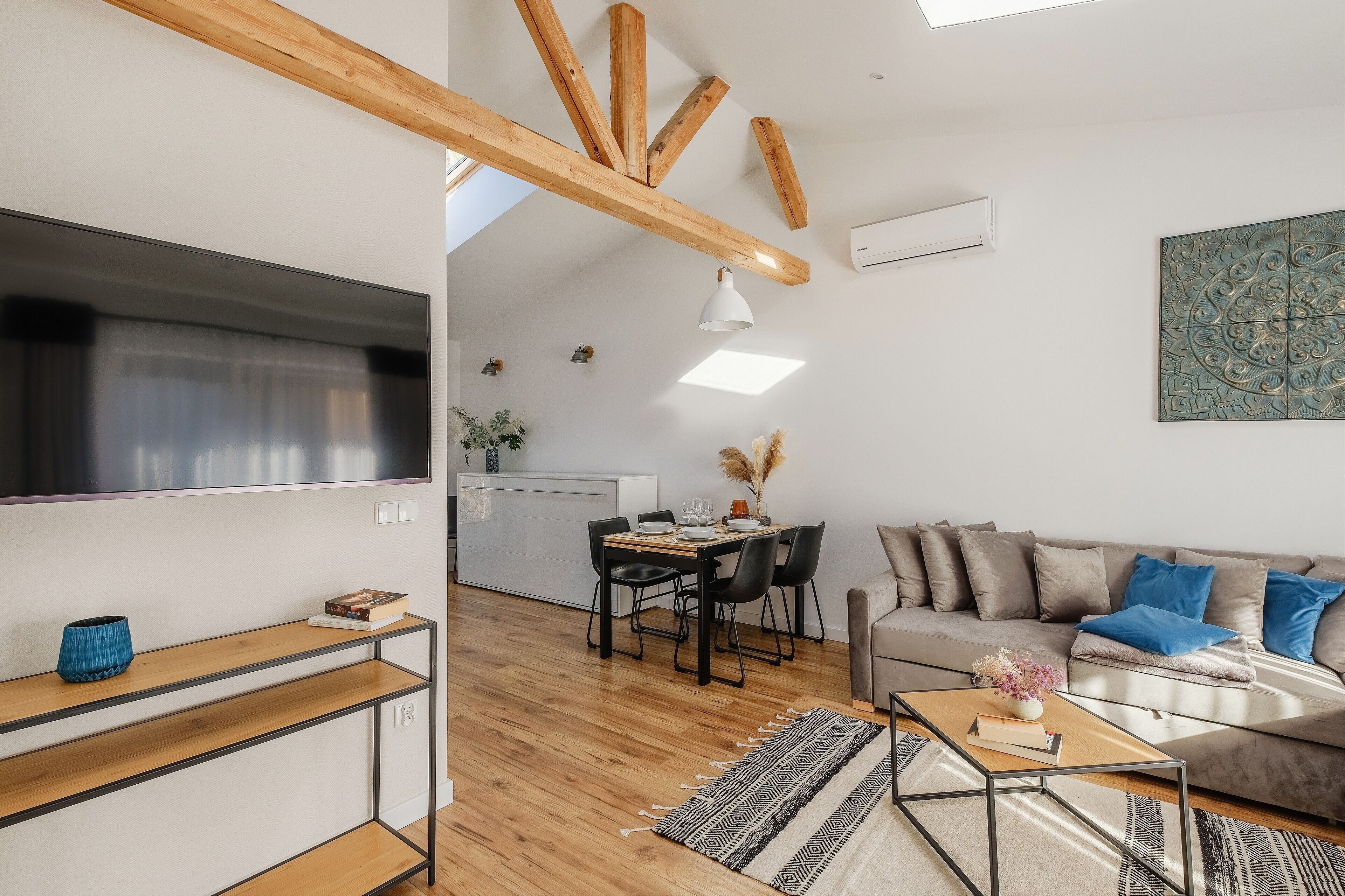 A modern living room with a sofa, coffee table, and dining area.