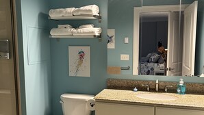 A bathroom with a toilet, sink, and towel rack. - The Surf - steps to the beach (Hampton)