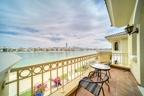 Un balcon avec vue sur une plage et le panorama urbain.