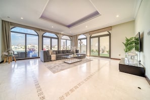 Un salón amplio con un sofá grande, una mesa de centro y un televisor de pantalla plana.