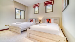 Ett hotellrum med två sängar, ett stort fönster och utsikt över omgivningarna.