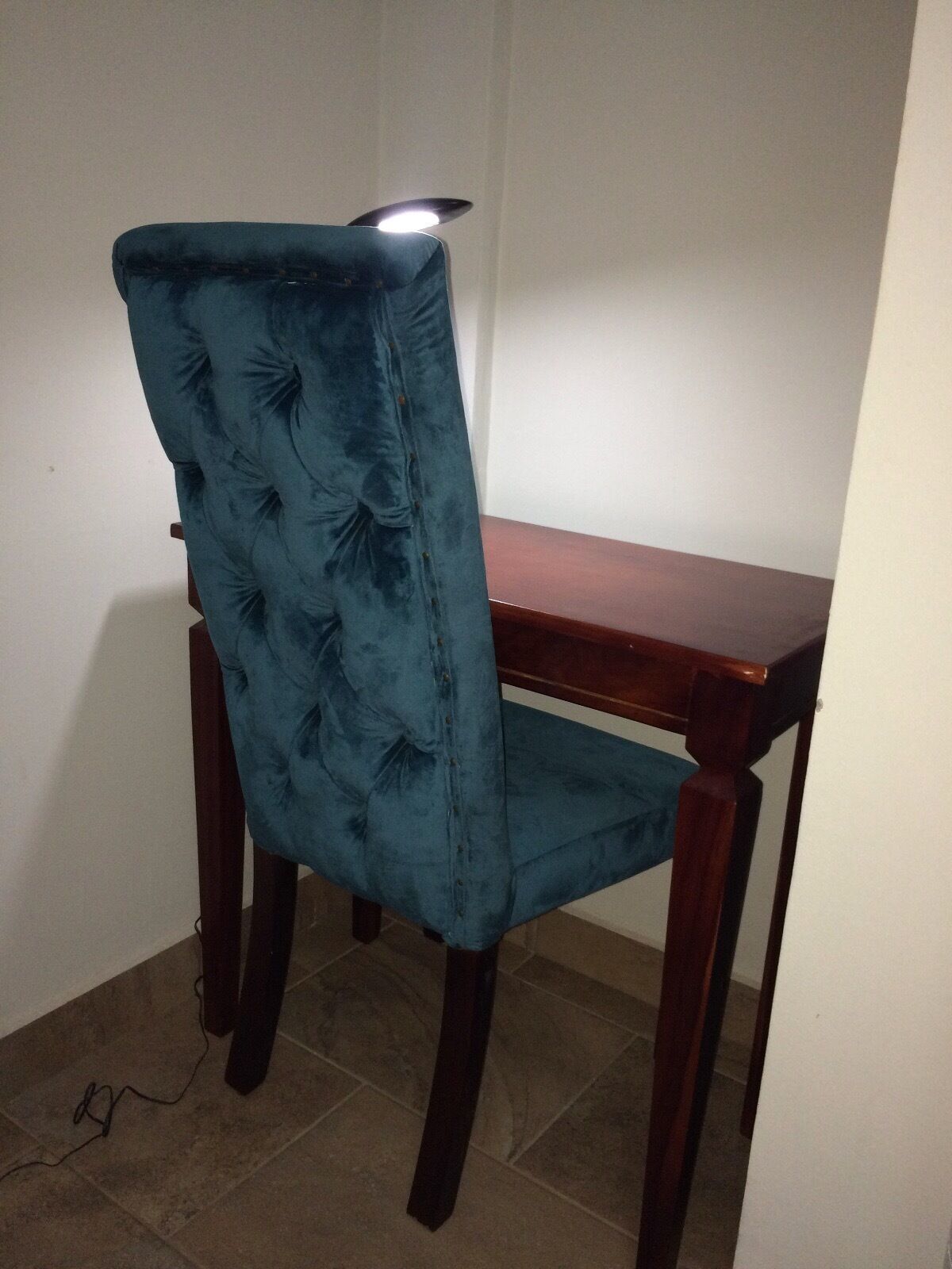 A chair with a high back and a wooden table beside it.