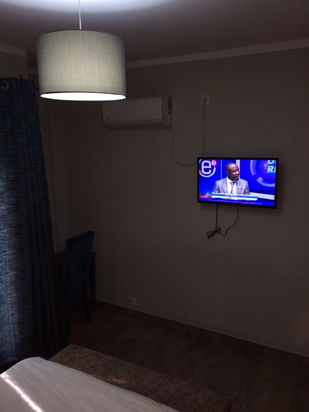 Una habitación con un televisor en la pared mostrando un noticiero.