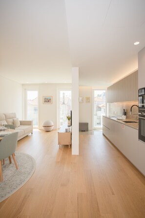A modern apartment with a living room, dining area, and kitchen. - Liiiving - Crystal Palace Apartment (Porto)