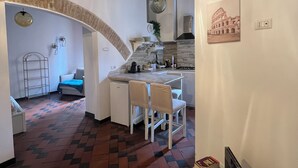 A compact kitchen with a dining area, a small refrigerator, and a dining table with chairs. - Trastevere Center, just a short walk from Piazza Trilussa (Roma)