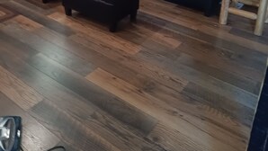 Interno di una baita di legno con un divano componibile, un poggiapiedi abbinato e un tavolino con una scatola.